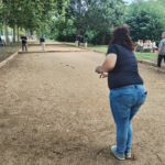 Personne de dos jouant à la pétanque.