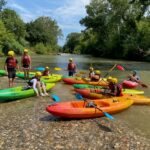 Le groupe sur le bord de l'eau laisse les kayaks