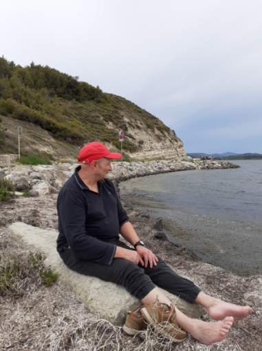 Un résident assis sur un rocher regarde l'eau