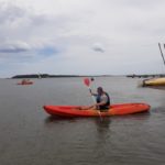 Un résident sur l'eau dans un kayak rouge pagaie