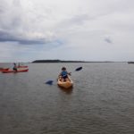 Un résident sur l'eau dans un kayak jaune pagaie