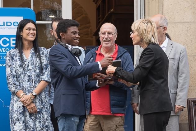 Un jeune homme reçoit un trophée des mains de la Présidente du Conseil Départemental, Hélène Sandragné