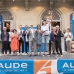 Un jeune homme fier soulève son trophée devant l'ensemble du public et des partenaires