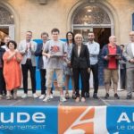 Un jeune homme pause avec son trophée auprès des partenaires