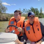 Deux jeunes hommes dans un bateau avec un gilet de sauvetage