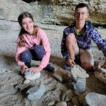 Deux jeunes font du Land'art avec des pierres