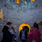 Le groupe de résidents au sein de la Cité de Carcassonne, sous un ciel multicolore