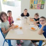 4 enfants à table avec leur accompagnatrice