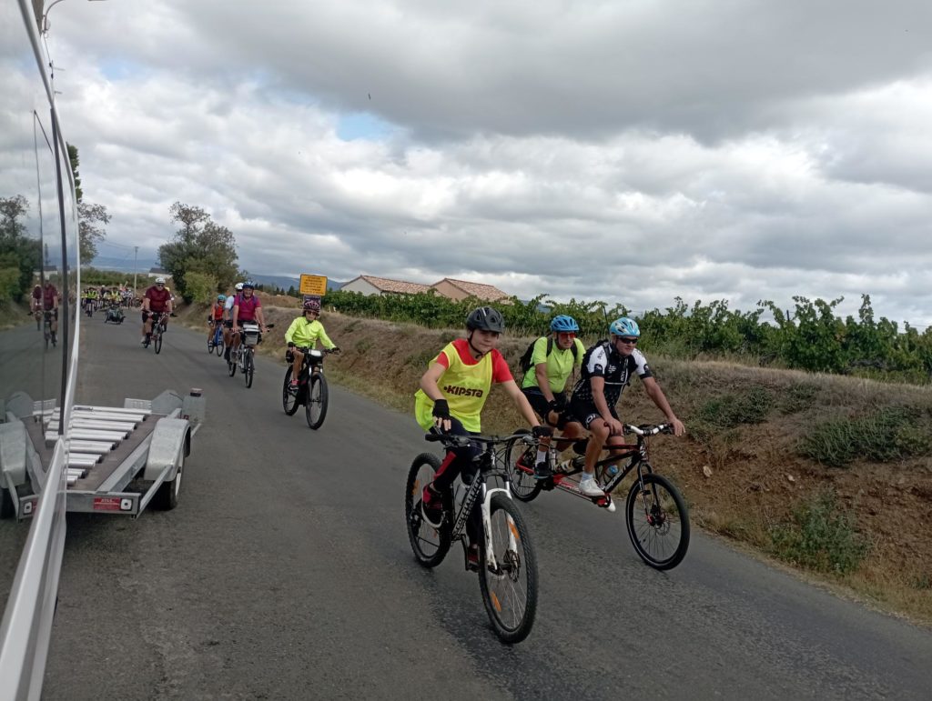 Pendant la course, les jeunes en chasuble jaune fluorescent, sur la route à vélo