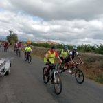 Pendant la course, les jeunes en chasuble jaune fluorescent, sur la route à vélo