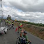 Pendant la course, les jeunes en chasuble jaune fluorescent, sur la route à vélo