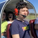 Trois jeunes et l'instructeur dans le cockpit avec leur casque et leur micro