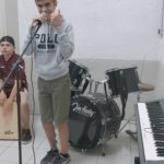 Un jeune homme au chant et en arrière plan un jeune homme assis