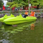 Deux jeunes sur un pédalo vert