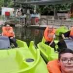 Cinq jeunes sur trois pédalos verts