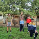 photo de 5 jeunes et en arrière plan des lamas