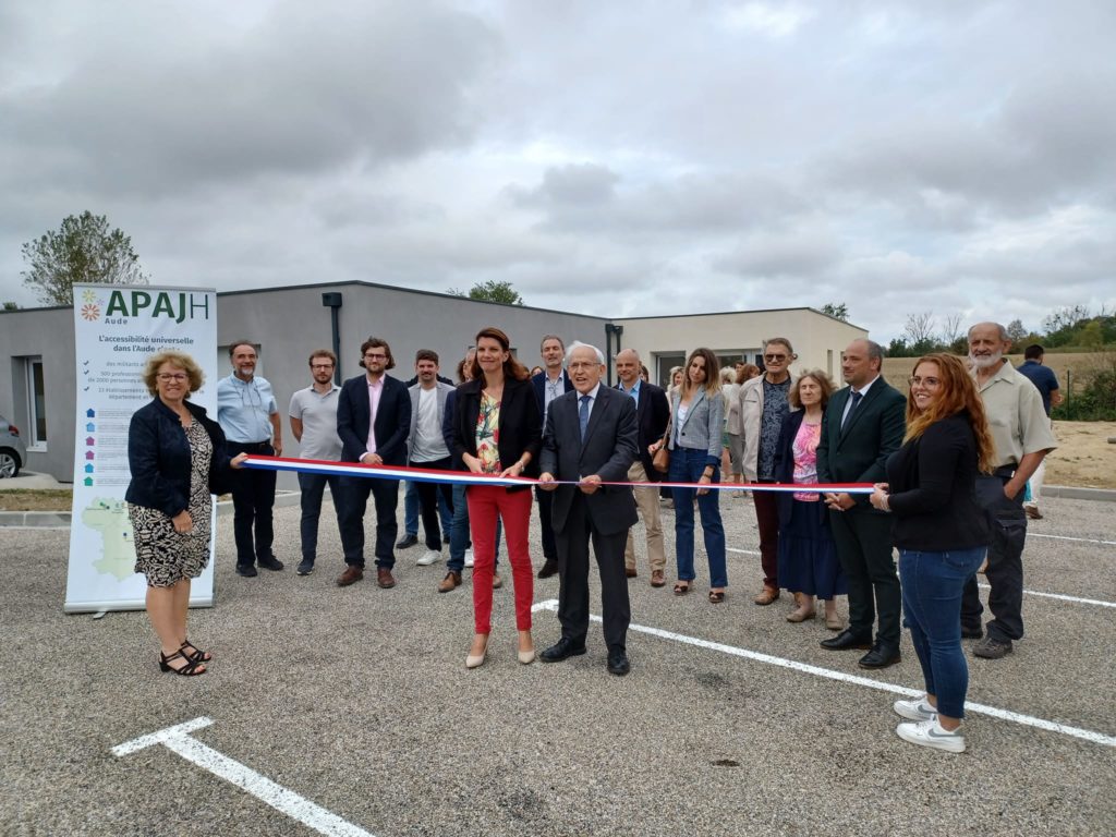 Charline Jégou, directrice du CMPP et le Président de l'APAJH Aude, Jean-Claude Rouanet coupent le ruban tricolore. EN arrière plan les salariés et partenaires ainsi que le bâtiment