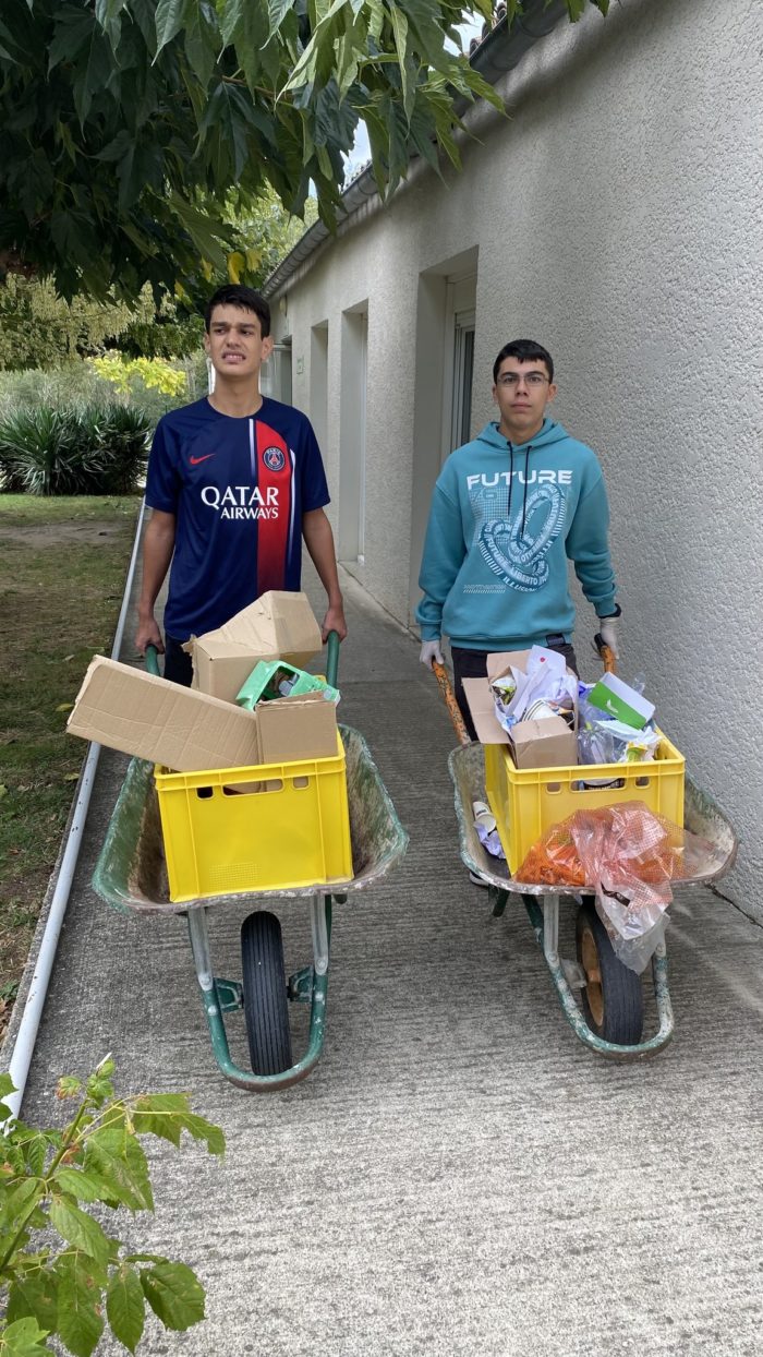 Deux jeunes avec des brouettes remplies de cartons