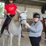 Deux résidents avec un cheval. L'un dessus et l'autre à terre tient la bride