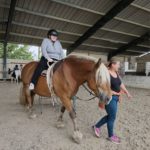 Une résidente à cheval et une accompagnatrice à terre