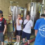 Les jeunes dans la cave devant les cuves inox