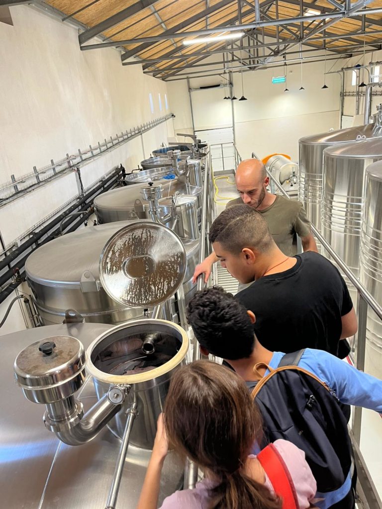 Les jeunes, accompagnés par Jérémy découvrent le vin dans les cuves