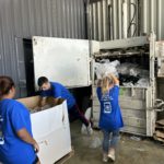 3 jeunes se servent du compacteur à cartons