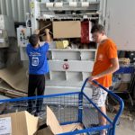 2 jeunes se servnt du compacteur à cartons