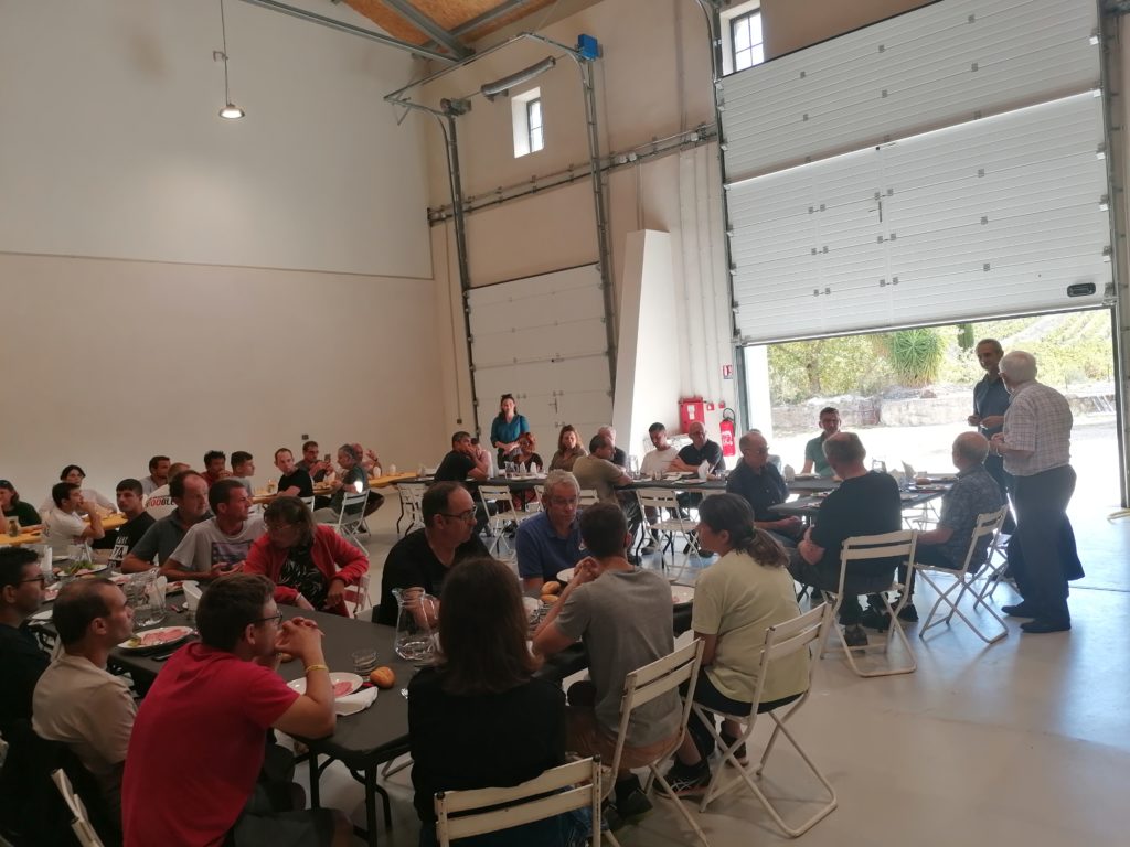 L'ensemble des travailleurs et invités autour d'une grande tablée dans la cave