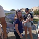 Deux jeunes filles avec une peluche devant un stand informatif sur la mer