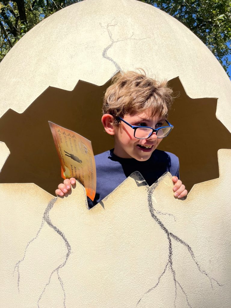 Un jeune garçon pose dans un faux œuf géant