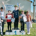 Un groupe d'enfants sur le podium les bras levés (course 2)