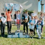 Un groupe d'enfants sur le podium les bras levés (course 1)
