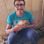 Un jeune homme avec un cochon d'Inde à poils longs dans les mains