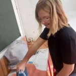 Une jeune fille repasse le tissus