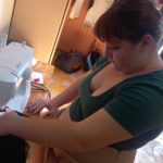 Une jeune fille manipule la machine à coudre