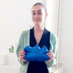 Une jeune fille montre son coussin bleu uni achevé