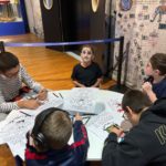 5 jeunes autour d'une table dessinent et sont maquillés pour Halloween