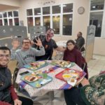 Des résidents dans le réfectoire autour d'une table décorée aux couleurs d'Halloween