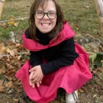 Une jeune fille déguisée avec une robe noire et fuschia