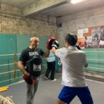 Deux jeunes sur le ring avec le professeur de boxe