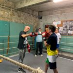 3 jeunes sur le ring avec leur professeur de boxe