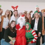 Photo de groupe des professionnels en tenues de Noël (déguisements de lutin, de Père Noël, de rennes,...)