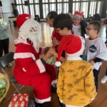 Le Père Noël, les jeunes et les professionnels durant la distribution de cadeaux