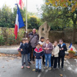 Les élèves près du porte drapeau devant le monument aux morts