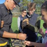 Un joueur de baseball aide les jeunes à mettre leur gant
