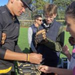 Un joueur de baseball aide les jeunes à mettre leur gant