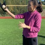 Une jeune fille avec un gant et la balle