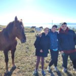 Trois jeunes près d'un cheval