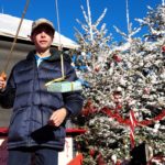 Un jeune homme avec une canne à pêche et au bout de l'hameçon un cadeau